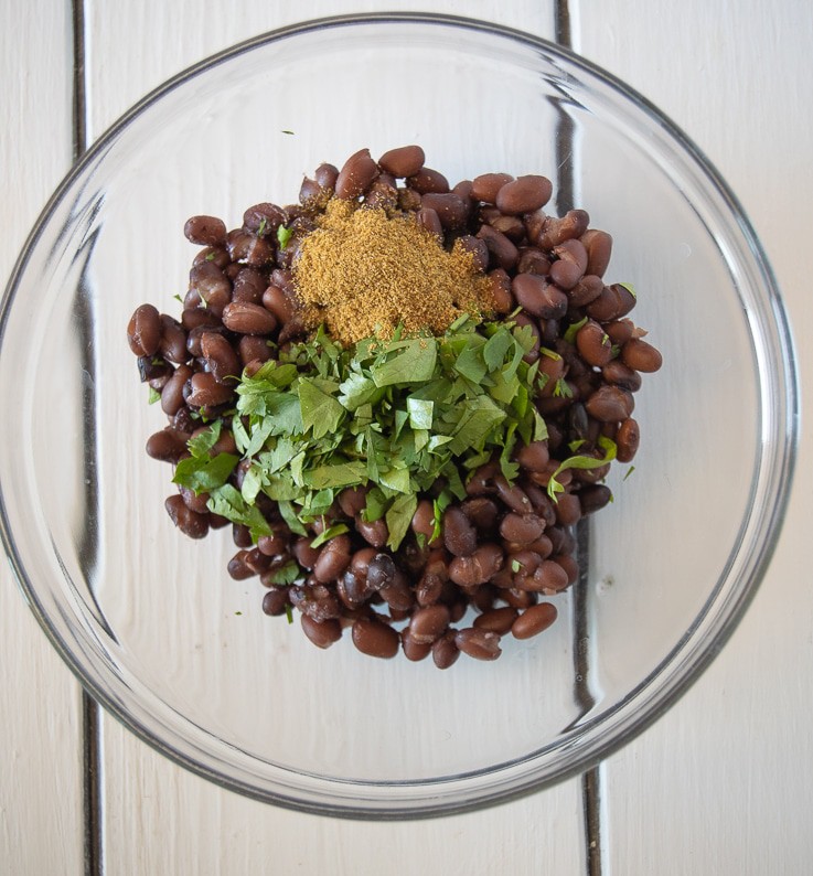 Black beans getting mixed with cumin and cilantro