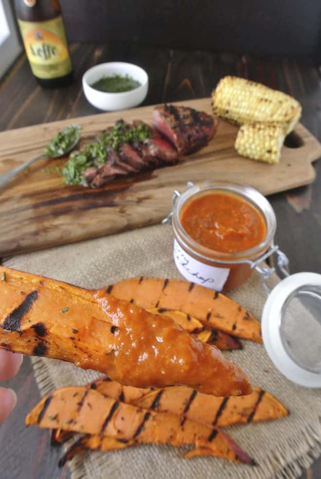 A grilled sweet potato wedge dipping in curry ketchup