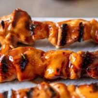 Chicken kabob skewers with grill marks coated in teriyaki sauce