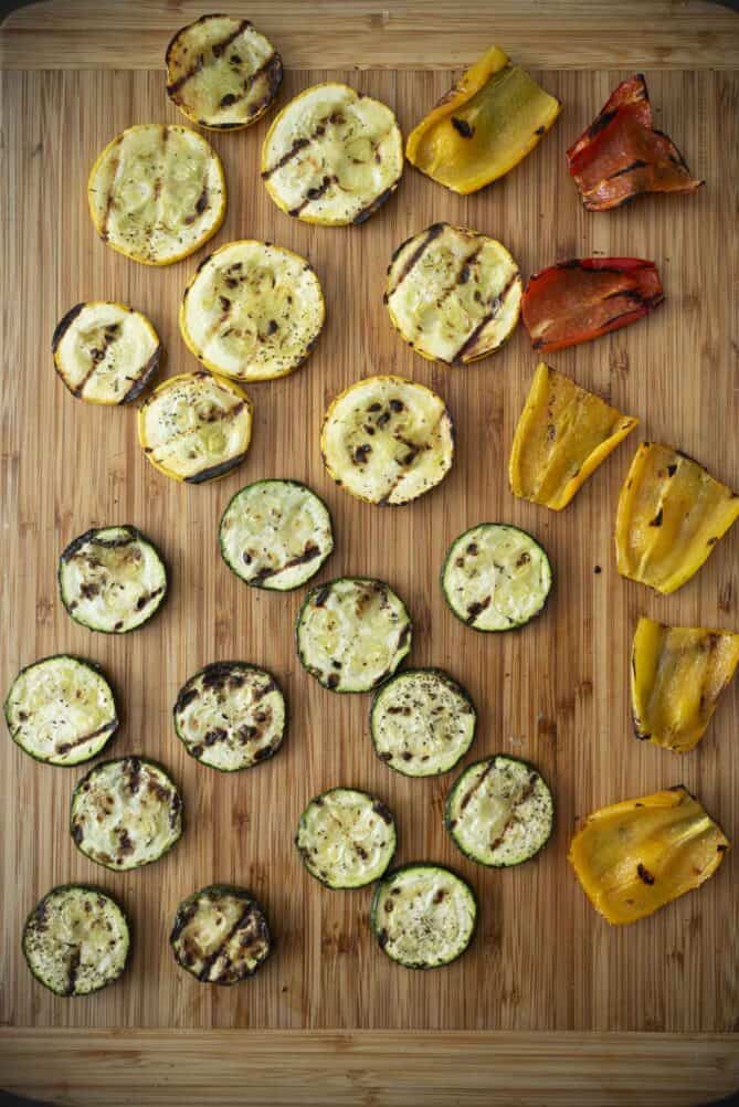 Grilled green and yellow squash slices and red and yellow peppers