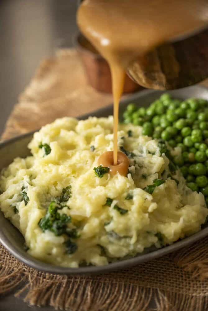 Pouring gravy over mashed potato