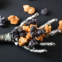A scary metal mummy hand holding Halloween popcorn
