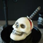 This Halloween skull and dagger cake is a fun, spooky centerpiece that will be sure to scare any Halloween party goers. This cake can also serve as desserts for  your guests, if they dare to eat it.