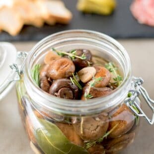 A closeup of brown mushrooms, herbs and garlic