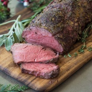 A sliced beef tenderloin coated with herbs