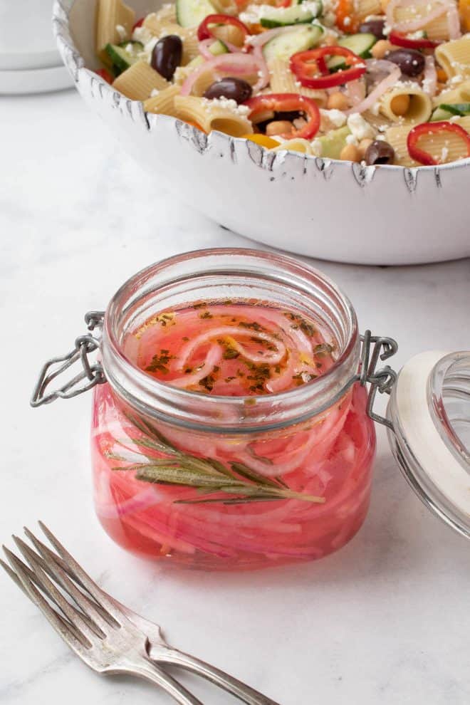 A jar filled with Herbed Pickled Red Onions