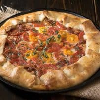 Herbed tomato galette served in a cast iron skillet