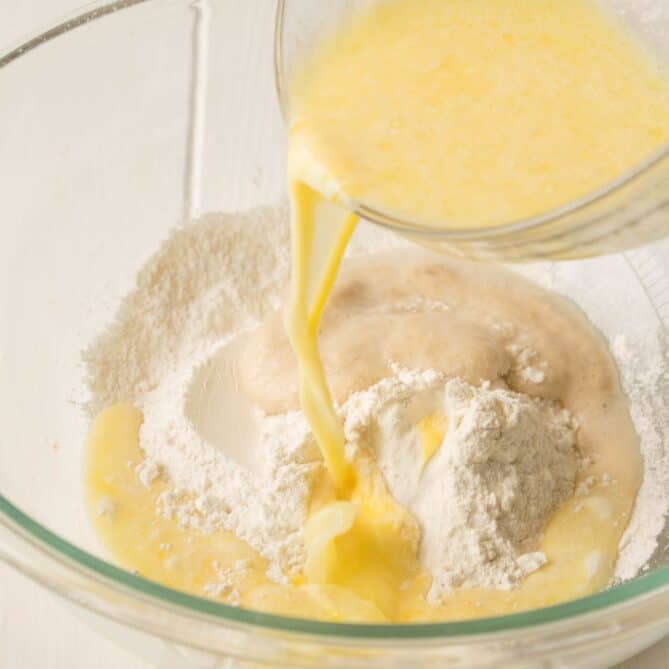 Pouring wet ingredients into dry ingredients for making bread