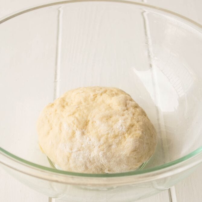 Bread dough rising in a glass bowl