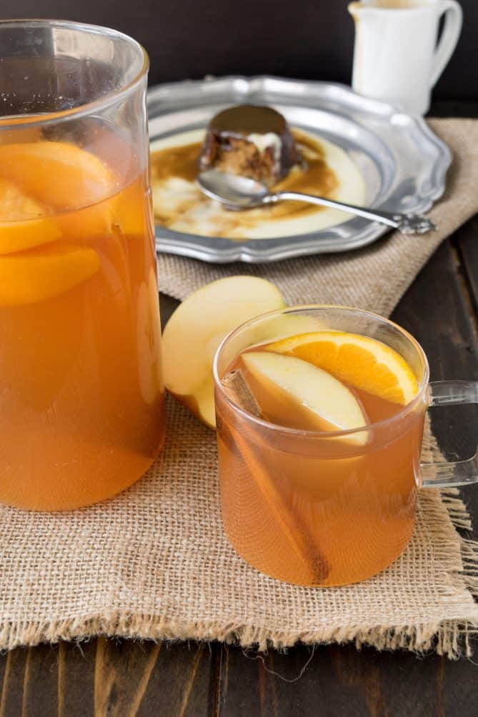 A pitcher of homemade apple cider with a glass mug full