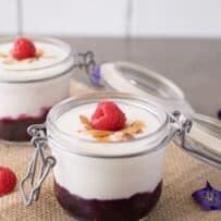 Fresh fruit in the bottom of a jar topped with yogurt and nuts