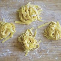 Freshly cut homemade tagliatelle pasta on a board