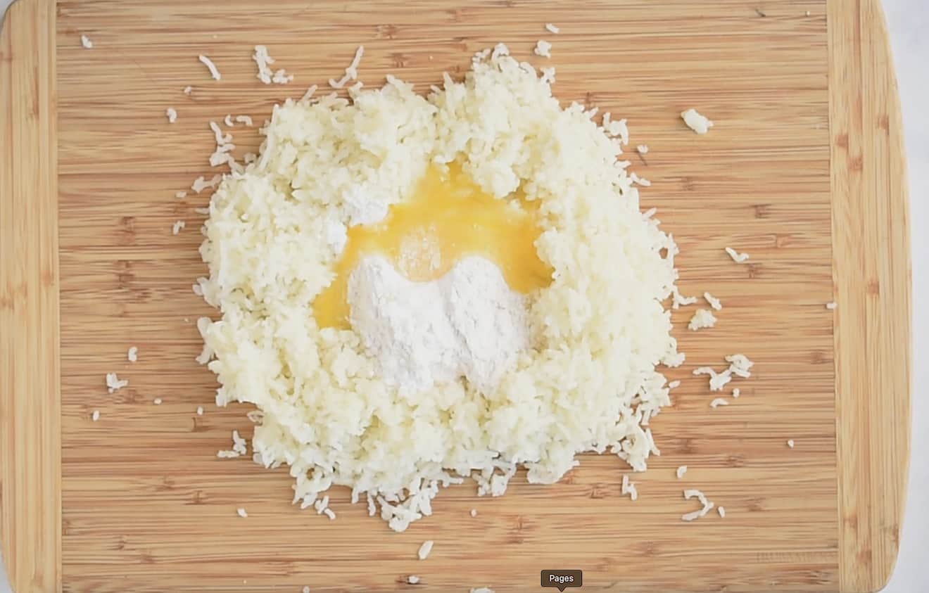 Mashed potato on a board getting mixed with flour and egg