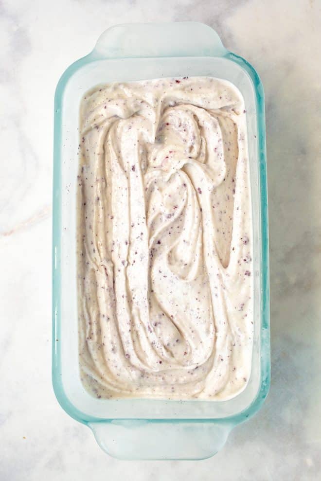 A container of blueberry and strawberry swirled vanilla ice cream