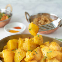 An Indian spiced potato wedge on a fork