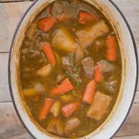 Large pieces of beef, carrots and vegetables in beef stew cooking in a pan