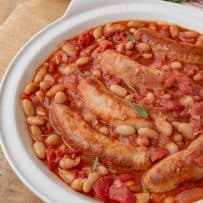 A closeup of the sausages nestled in the beans and tomato sauce
