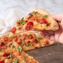 Holding a slice of Italian sausage and caramelized onion pizza