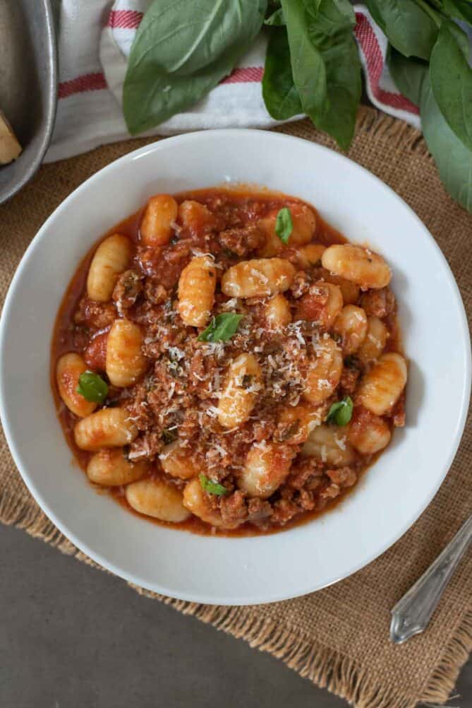 Gnocchi ragu in a white bowl viewed from overhead