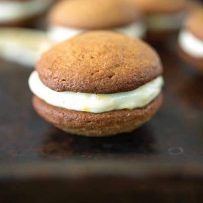 A side image of a cookie where you can see the flecks of lemon zest in the cream cheese filling