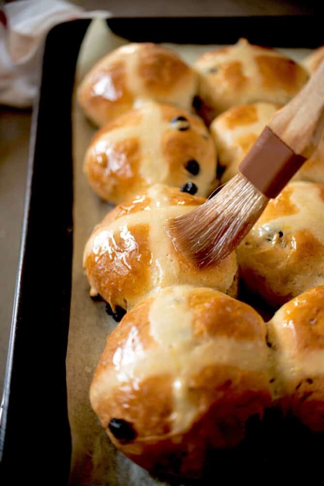 Brushing glaze over hot cross buns
