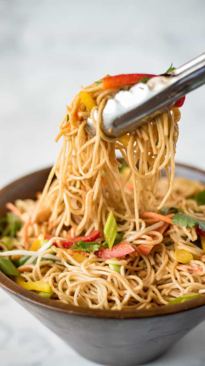 Lemongrass vegetable noodle salad being served using tongs