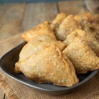 8 triangle shaped samosa on a pewter plate