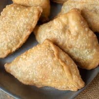 A closeup of samosas lying down showing the browned outside