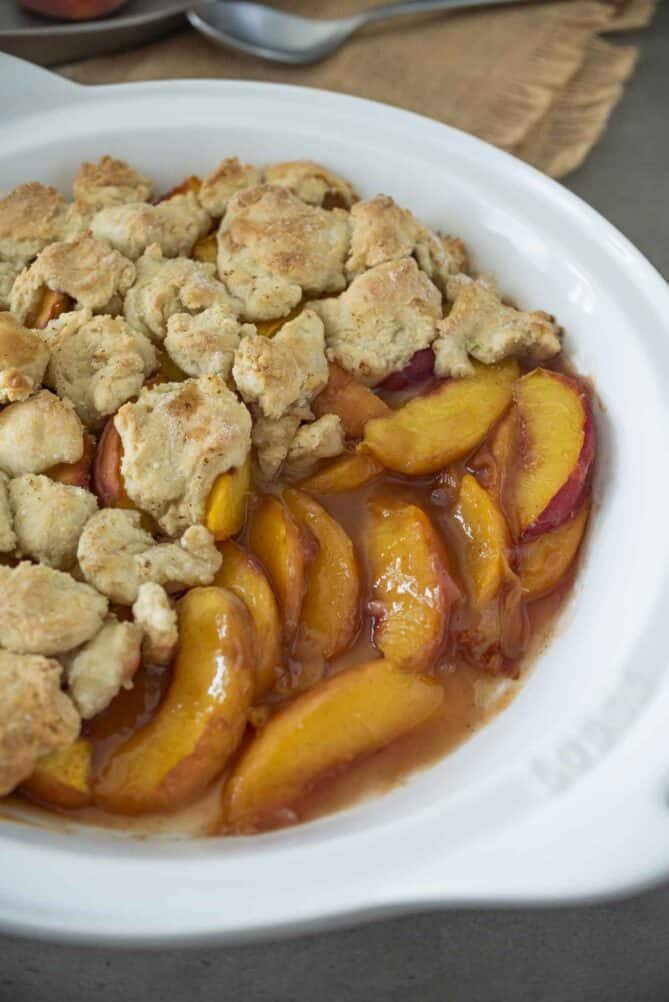 Peach cobbler in a white round bowl