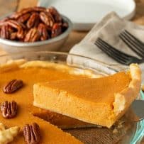 Lifting a slice of sweet potato pie from a pie pan