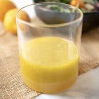 Meyer lemon marinade and dressing in a glass container with a salad