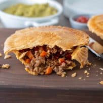 A minced beef and onion pie cut open showing the beef and vegetables inside