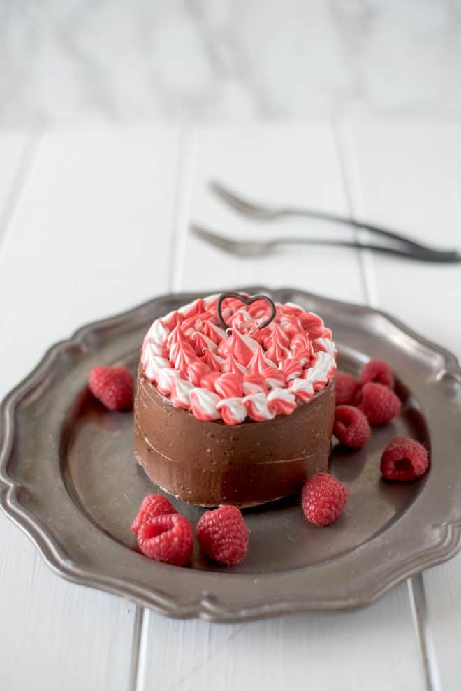 Mini chocolate cake for two on a grey plate with fresh raspberries
