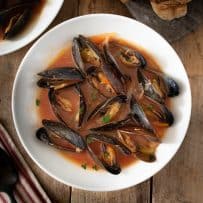 A bowl of mussel soup with crusty bread
