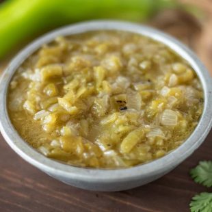 Chopped hatch green chiles in a sauce in a grey bowl