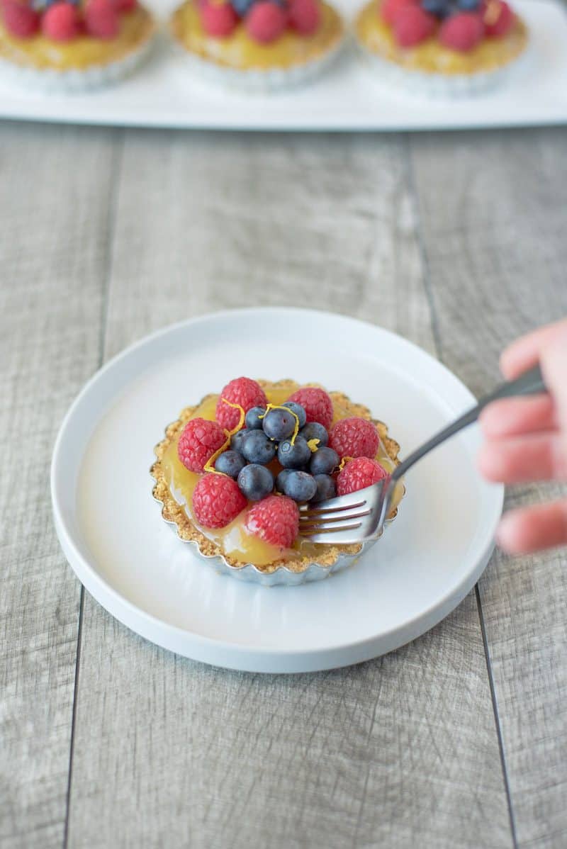 No bake berry lemon tartlets are an easy and very spring-like dessert. With a lemon graham cracker crust, delicious lemon curd filling and topped with fresh berries these tartlets are brightly colored berry treats.