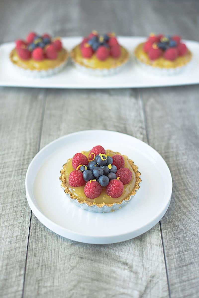 No bake berry lemon tartlets are an easy and very spring-like dessert. With a lemon graham cracker crust, delicious lemon curd filling and topped with fresh berries these tartlets are brightly colored berry treats.