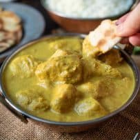 Dipping a piece of naan bread in a curry