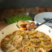 A serving spoon of lamb, carrots and potatoes