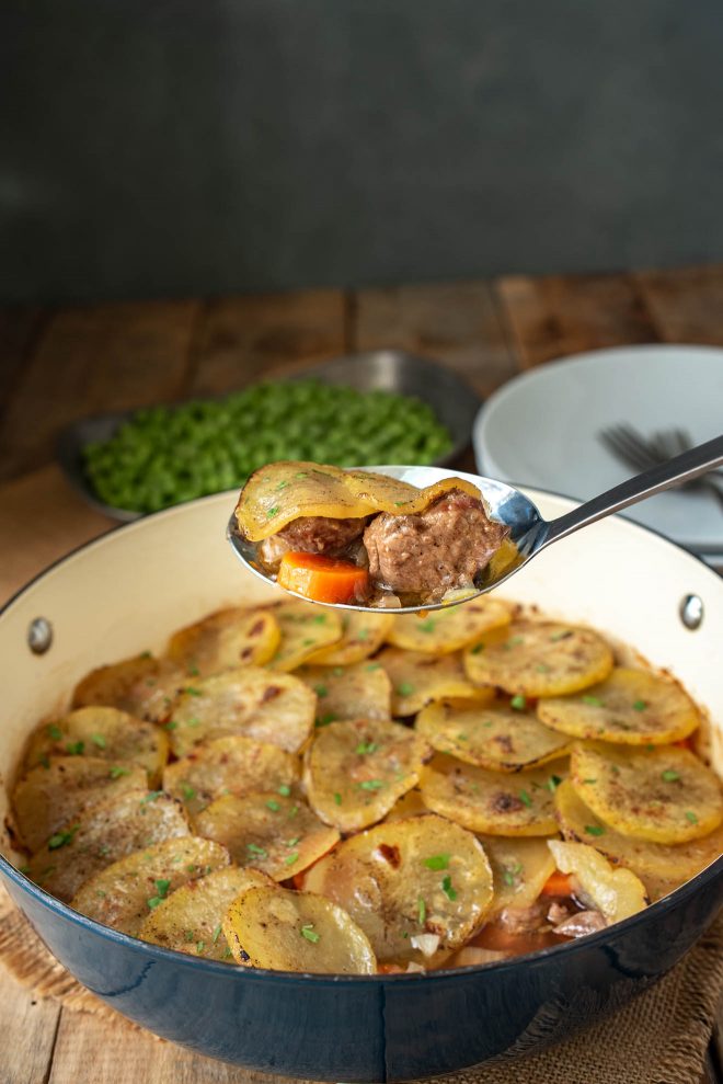 A serving spoon of lamb, carrots and potatoes