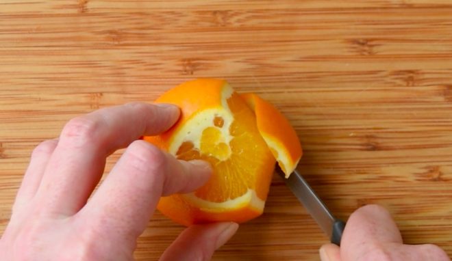 Cutting the peel off an orange