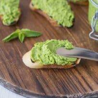 Spreading pea and mint pesto onto a crostini