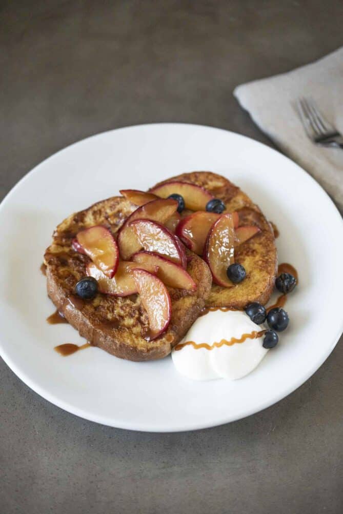 Pain perdu/French toast slices topped with peaches and caramel sauce