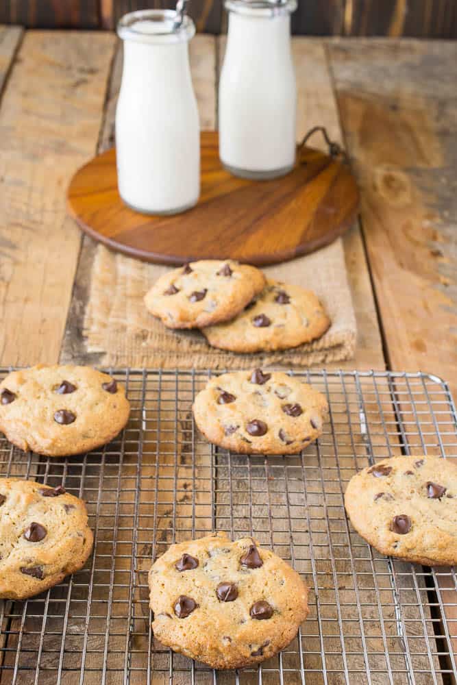 Peanut butter chocolate chip cookies cooling on a wire rack with mini bottles of milk