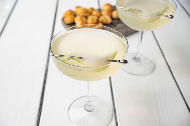 Pear Ginger Champagne Cocktail in a coupe glass with a pear slice on a drink skewer
