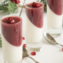 3 small glasses of pomegranate panna cotta with spoons