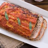 A whole pork apple and sage meatloaf on a long white platter