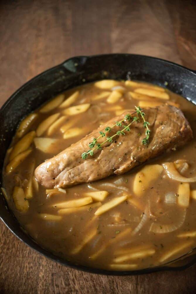 A pork tenderloin simmering in gravy