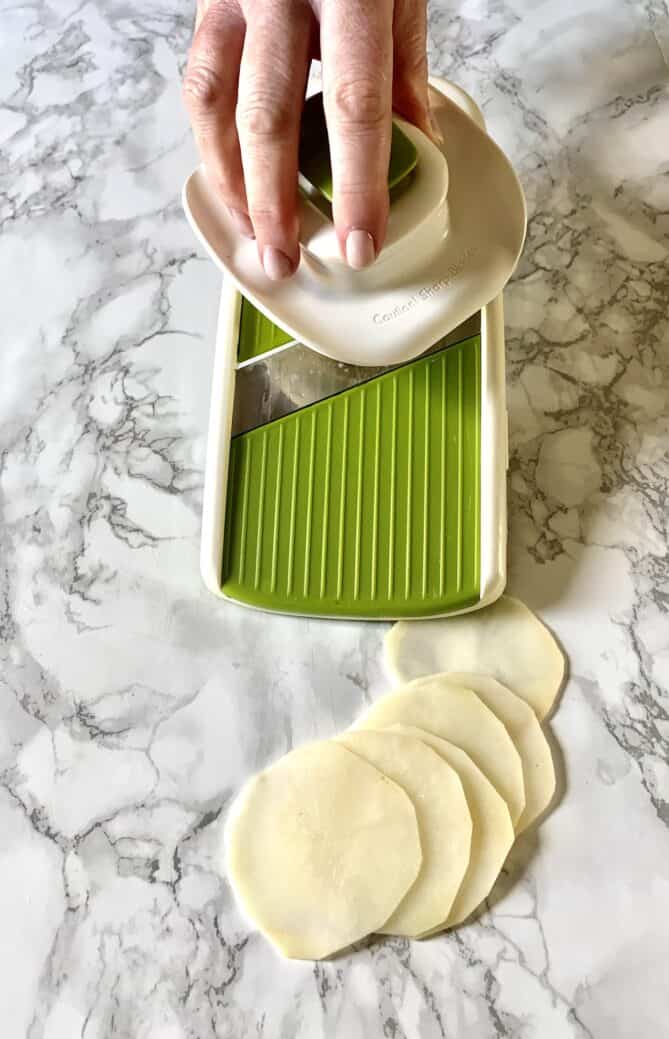 Slicing potatoes on a mandoline