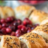 Sausage meat wrapped in puff pastry garnished with sesame seeds